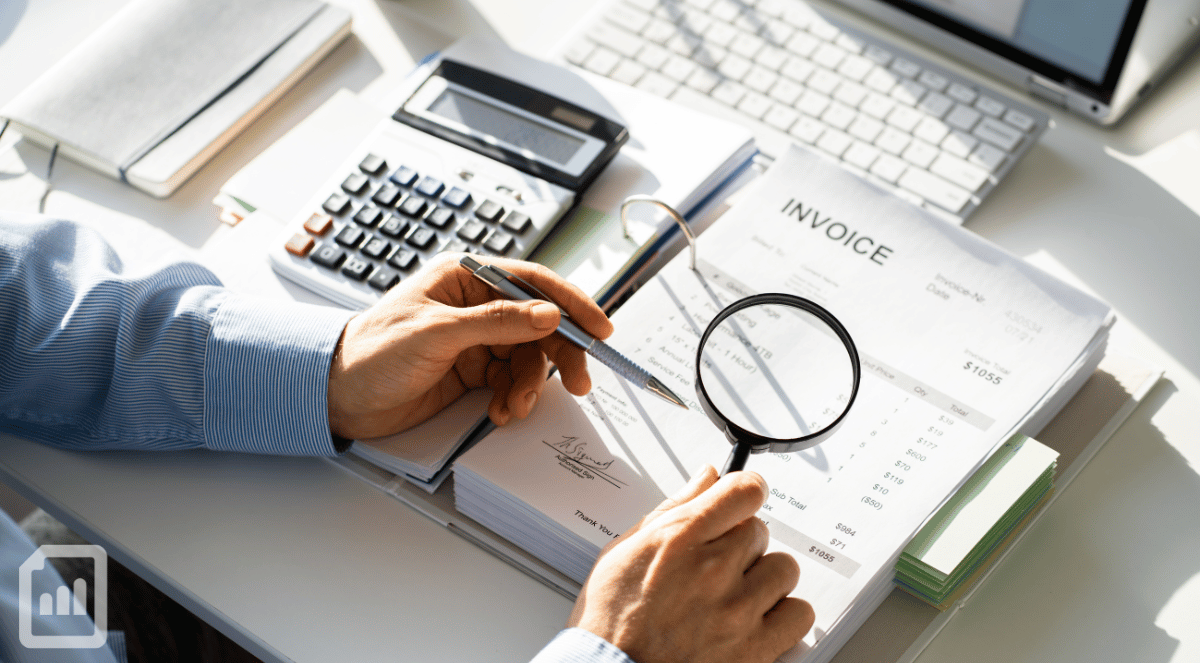someone using a magnifying glass to look at financial statements