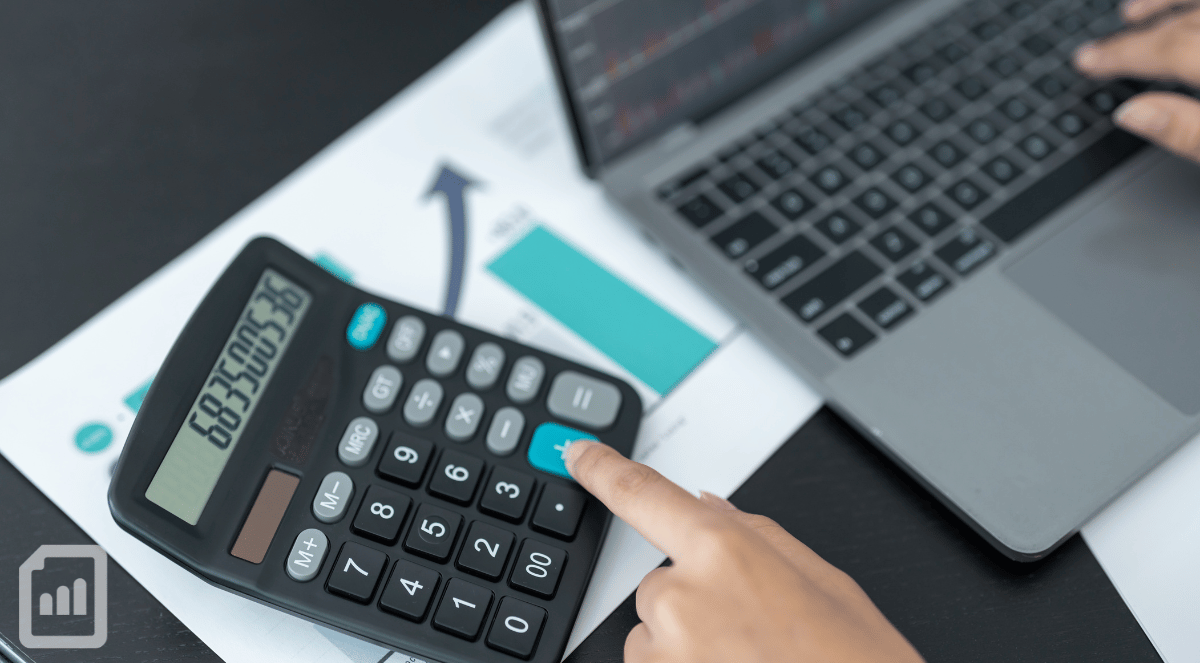 Close-up of a businessman working on a calculator and a laptop